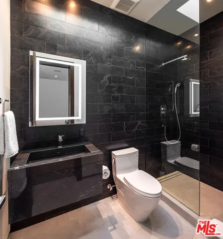 a bedroom with a bed a table and a potted plant