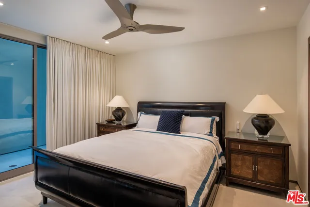 a bedroom with two beds and a ceiling fan
