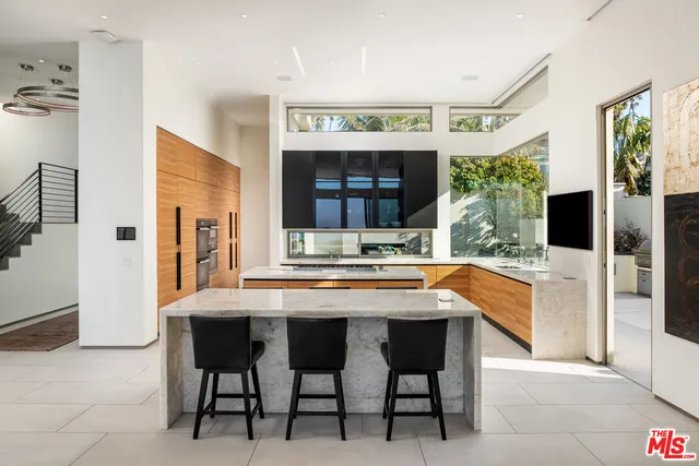 a dining hall with stainless steel appliances kitchen island granite countertop a granite counter tops and chairs