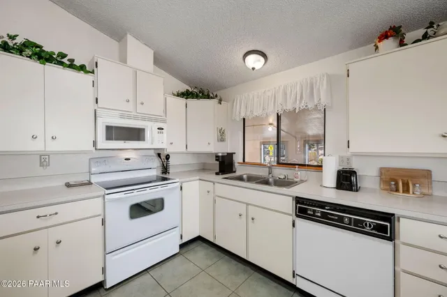 a kitchen with white cabinets sink and white appliances