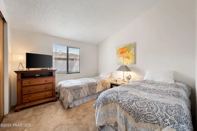 a bedroom with two bed and a flat screen tv