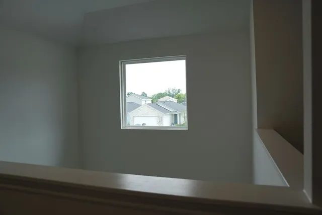 a view of a small space with wooden floor and a window