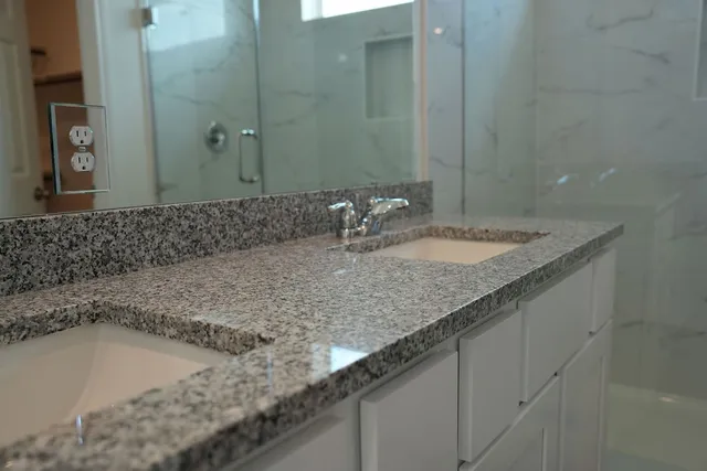 a bathroom with a granite countertop sink and a mirror