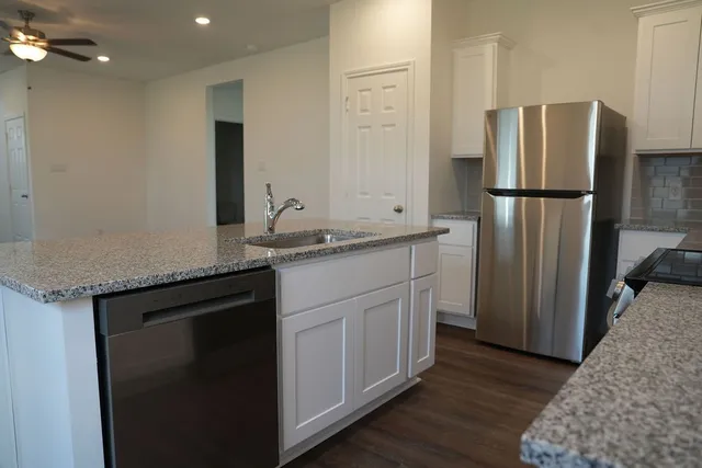 a kitchen with a sink refrigerator and microwave