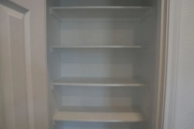 a view of walk in closet with empty racks