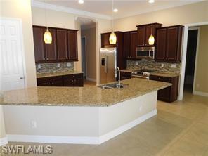 6853 Il Regalo Circle Naples, FL 34109 - Photo 3 of 13 a large kitchen with kitchen island a sink and refrigerator