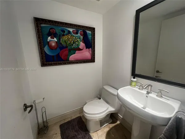 a bathroom with a toilet a sink and view kitchen