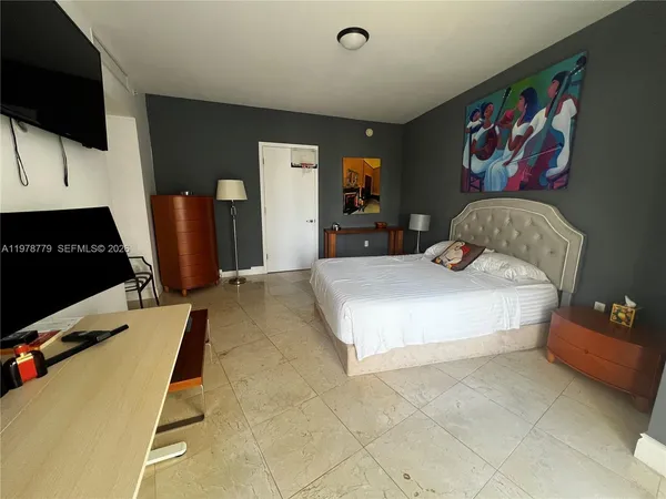 a bedroom with a bed and flat screen tv