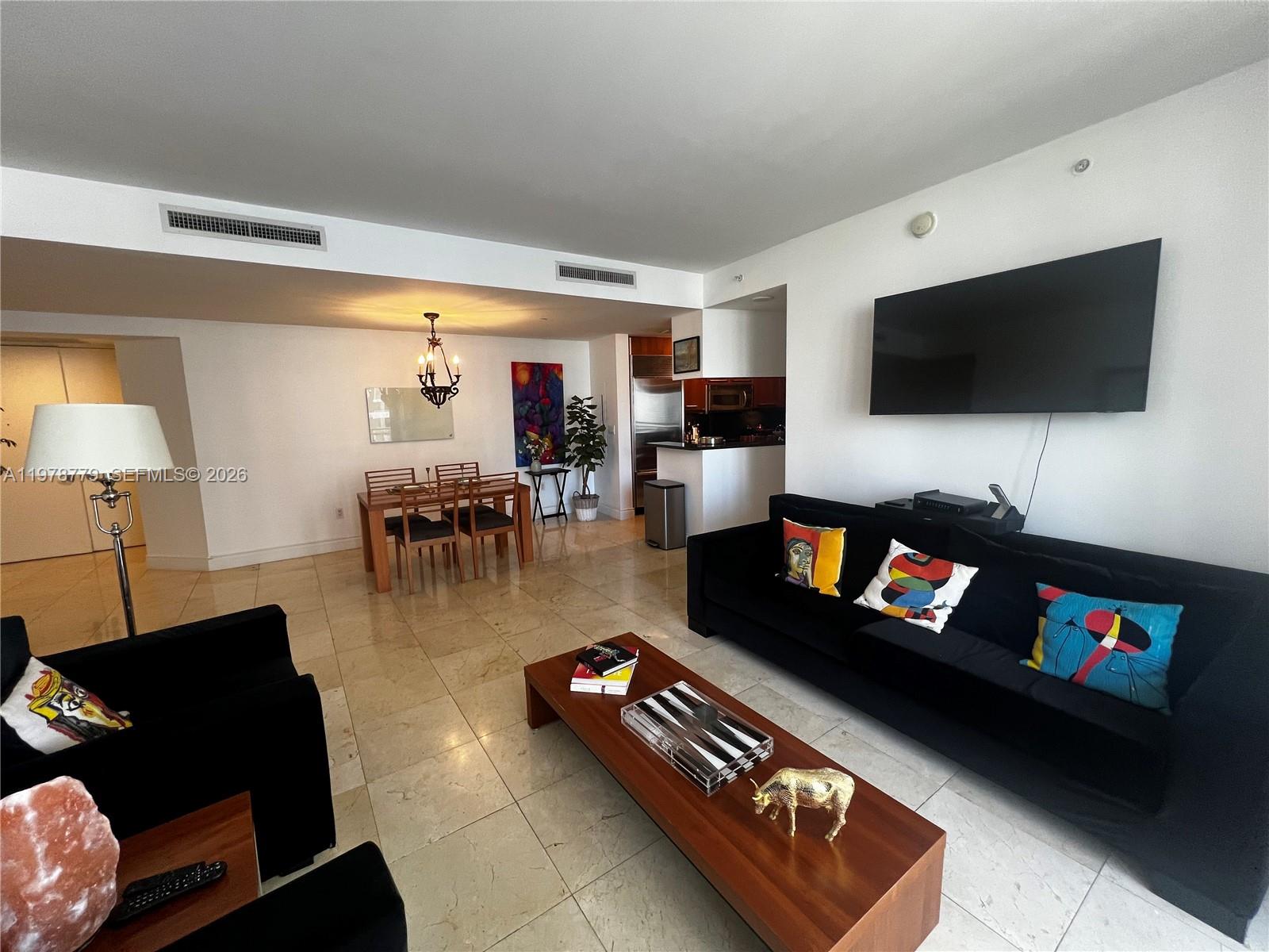 901 Brickell Key Boulevard, Unit 1001 Miami, FL 33131 - Photo 9 of 18 a living room with furniture and a flat screen tv