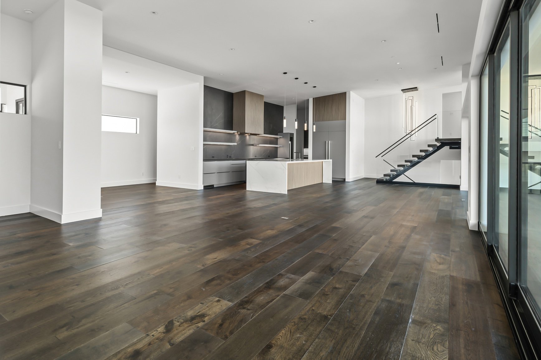 1702 Moonlight Trace Spicewood, TX 78669 - Photo 12 of 40 Unfurnished living room featuring dark wood-type flooring and stairs