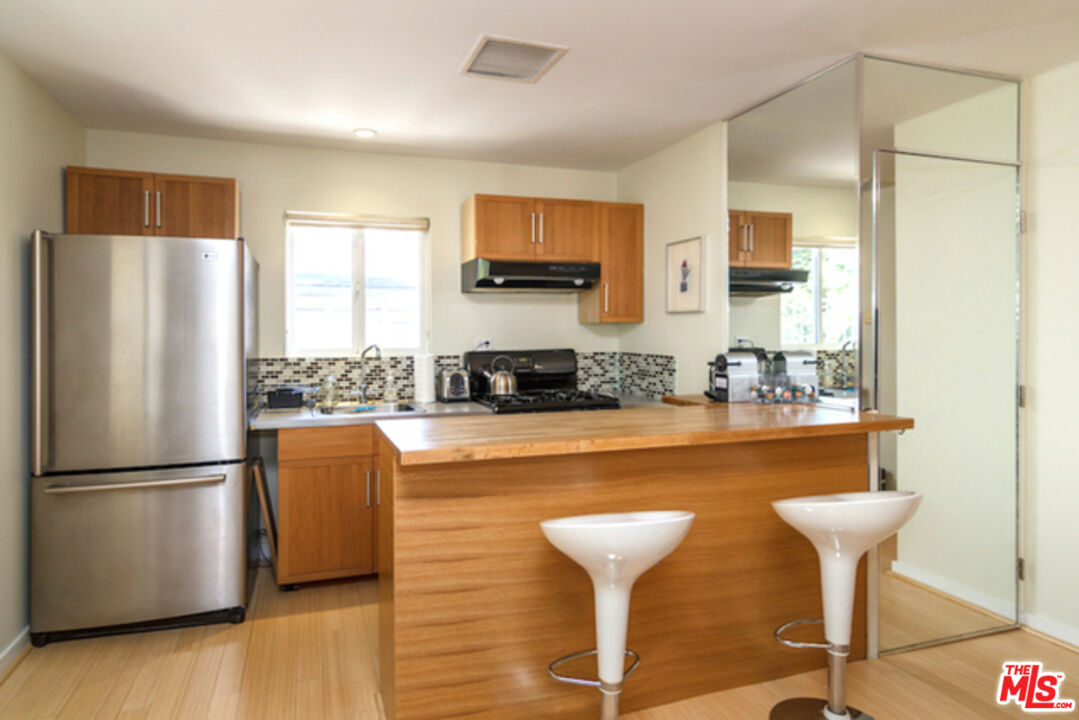 8152 Amor Road Los Angeles, CA 90046 - Photo 22 of 27 a kitchen with stainless steel appliances granite countertop a refrigerator and a stove top oven