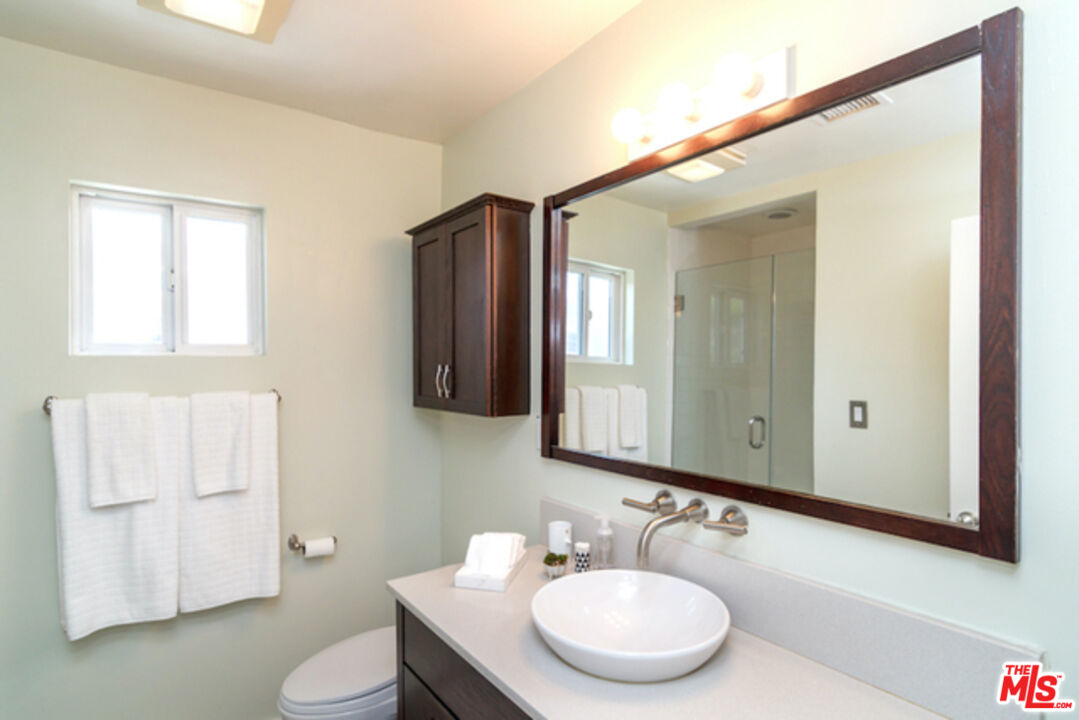 8152 Amor Road Los Angeles, CA 90046 - Photo 23 of 27 a bathroom with a granite countertop sink toilet and mirror