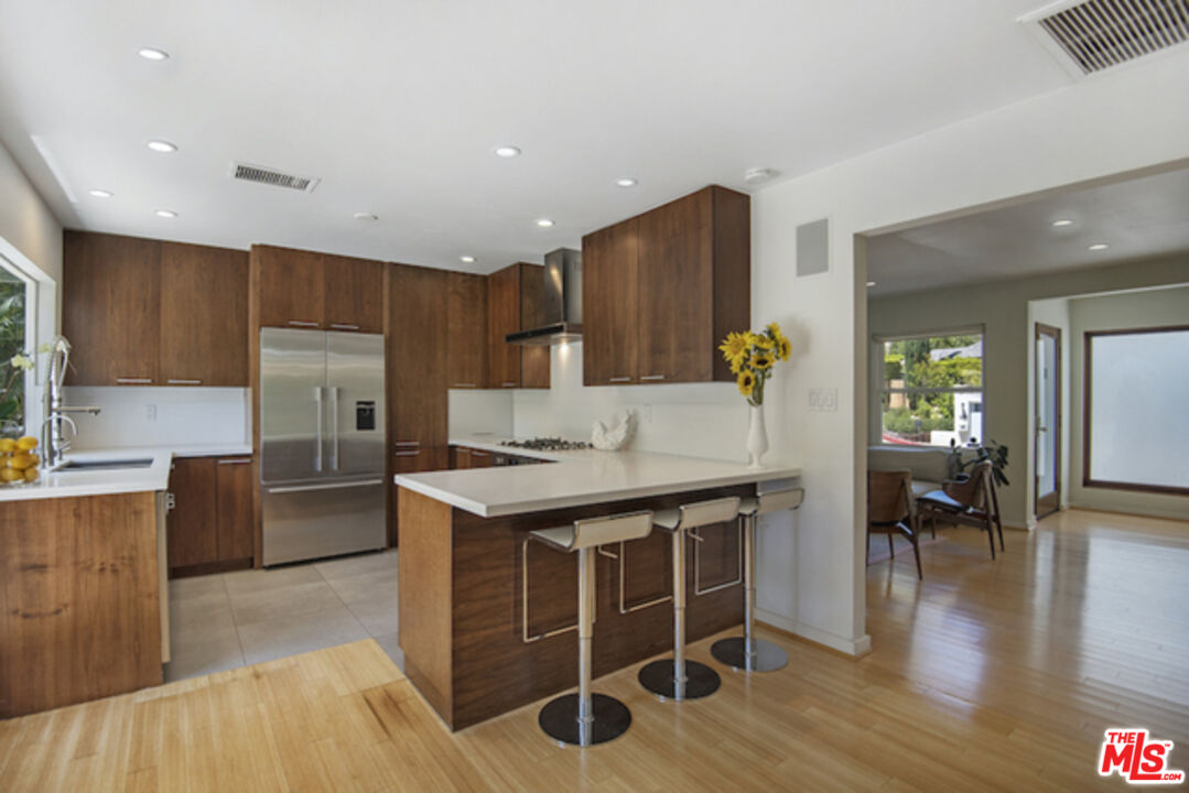 8152 Amor Road Los Angeles, CA 90046 - Photo 6 of 27 a kitchen with granite countertop a stove top oven a sink a dining table and chairs