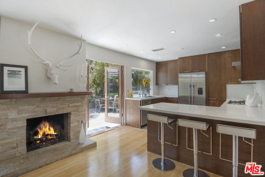 8152 Amor Road Los Angeles, CA 90046 - Photo 7 of 27 a kitchen with a wooden floor and a fireplace