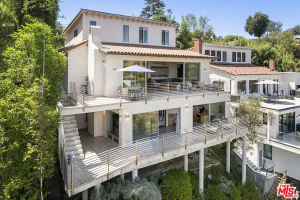 a view of a house with roof deck and furniture