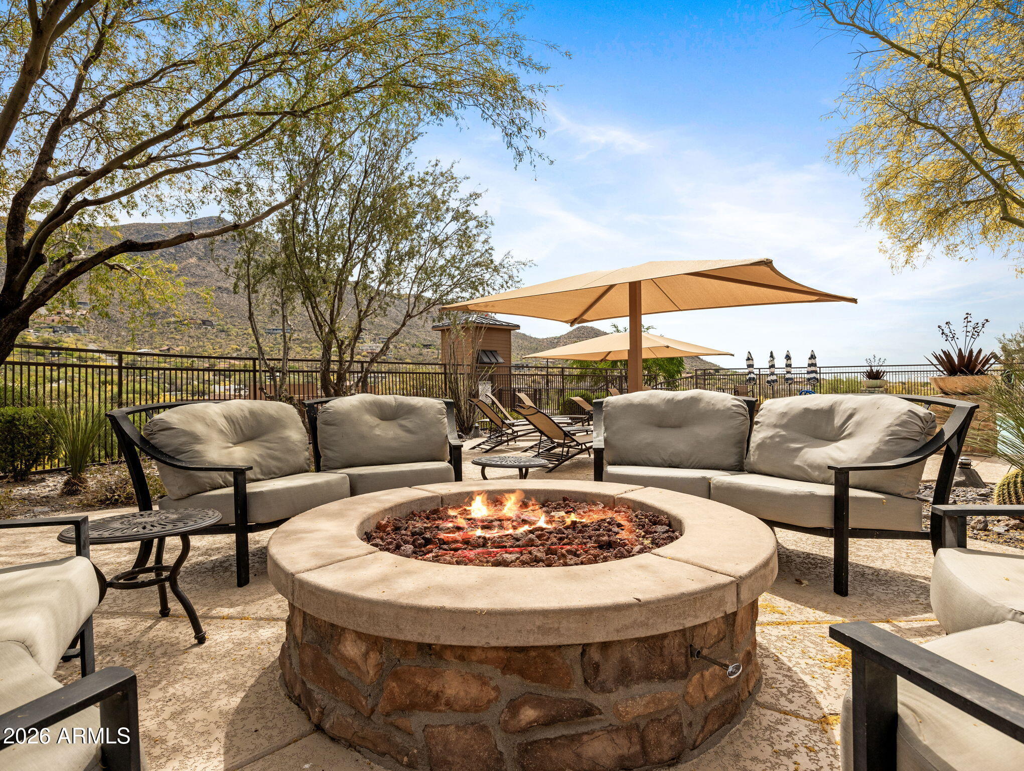 36600 North Cave Creek Road, Unit B14 Cave Creek, AZ 85331 - Photo 28 of 29 a view of a patio with couches table and chairs under an umbrella with a fire pit