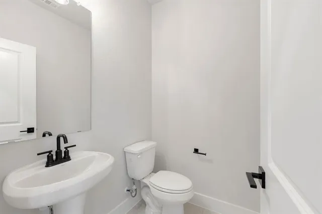a bathroom with a sink a toilet and a mirror