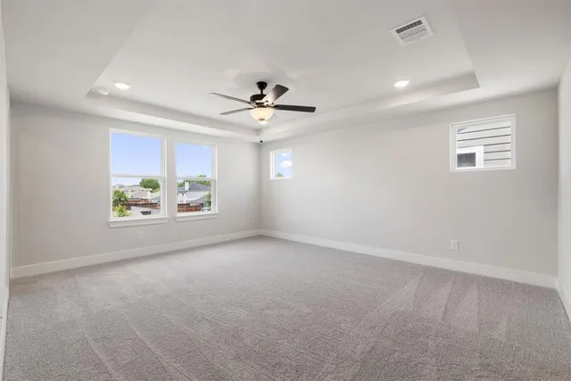 an empty room with windows and ceiling fan