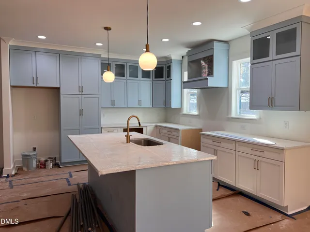 a kitchen with a sink dishwasher a stove a refrigerator and cabinets with wooden floor