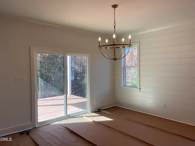a view of a room with window wooden floor and chandelier