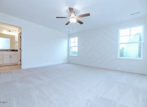an empty room with a window and a ceiling fan