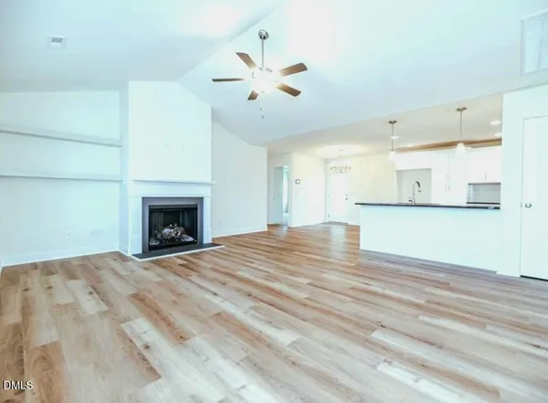 a view of empty room with wooden floor and fireplace