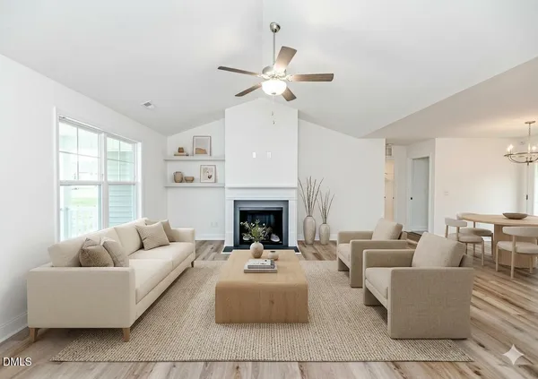 a living room with furniture a fireplace and a chandelier