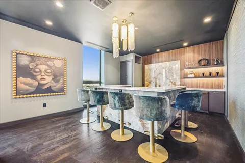 a kitchen with stainless steel appliances kitchen island granite countertop a dining table and chairs with wooden floor