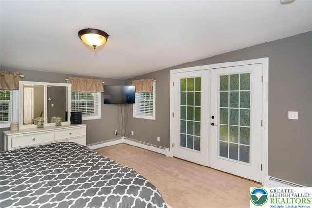 a view of a bedroom with wooden floor and a large window