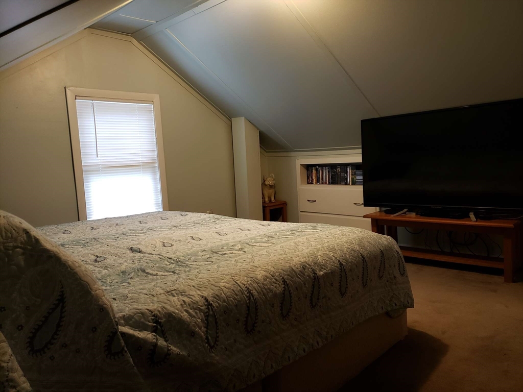 32 Birch Road Natick, MA 01760 - Photo 23 of 38 a bedroom with a bed and a flat screen tv