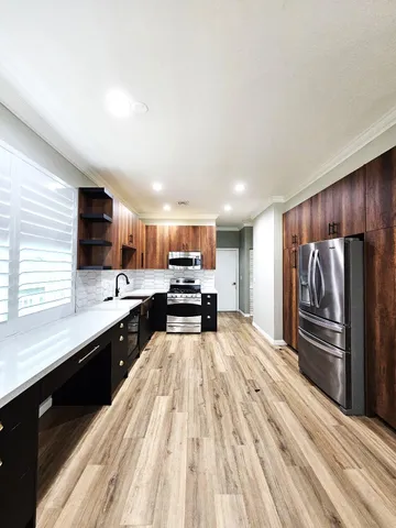 a kitchen with wooden cabinets and a stove top oven