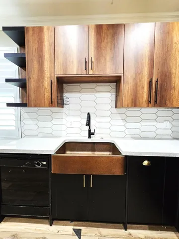 a view of a kitchen with wooden floor and stainless steel appliances