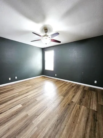 a view of a hallway with wooden floor and windows
