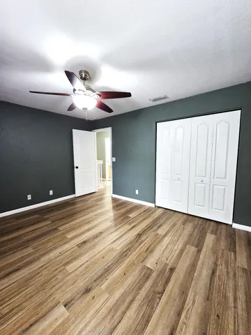 a view of an empty room with a window and chandelier