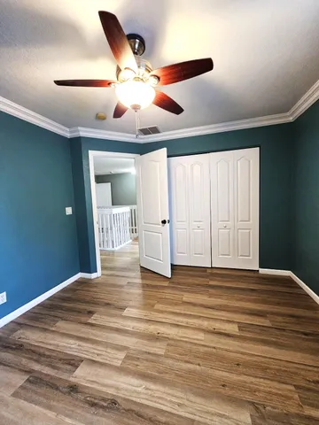 a view of room with wooden floor and fan