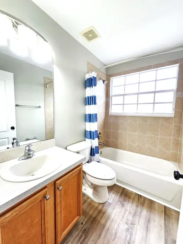 a view of empty room with window and wooden floor