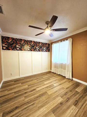 a view of a room with wooden floor and small window