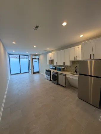 a kitchen with stainless steel appliances granite countertop a refrigerator a sink a stove a microwave and white cabinets