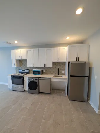 a large kitchen with stainless steel appliances granite countertop a stove and a refrigerator