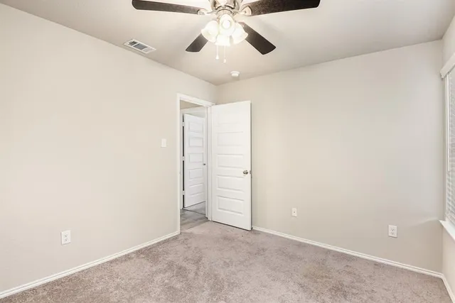 an empty room with closet and a chandelier fan