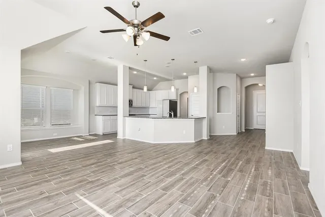 a view of a kitchen with wooden floor and a ceiling fan