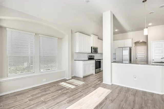 a view of kitchen with wooden floor and electronic appliances