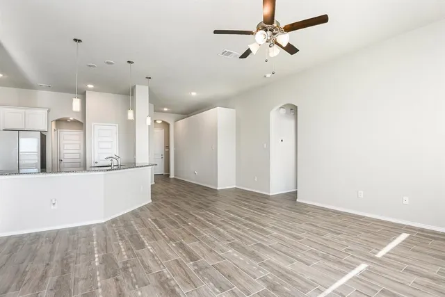 a view of an empty room with window and a ceiling fan