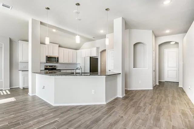 a kitchen with stainless steel appliances granite countertop a refrigerator and a stove top oven