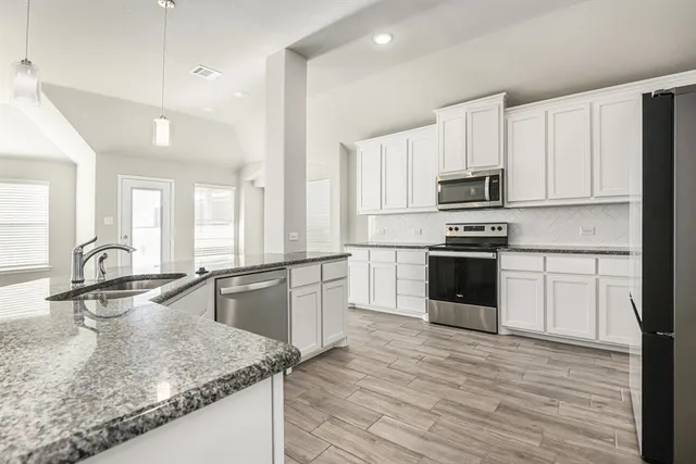 a kitchen with stainless steel appliances granite countertop a sink stove and refrigerator