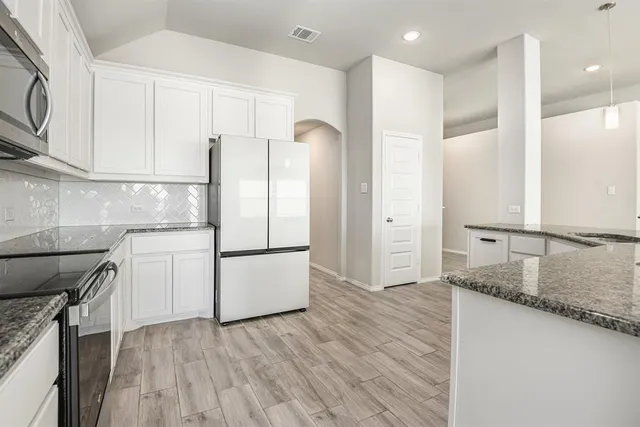 a kitchen with a refrigerator a sink and cabinets
