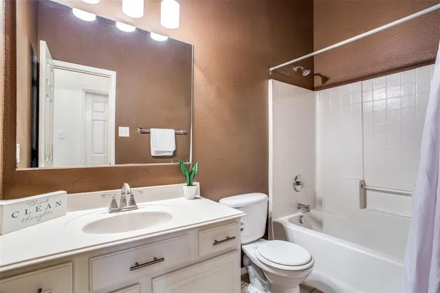 a bathroom with a sink vanity mirror and toilet
