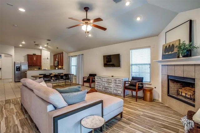 a living room with furniture a fireplace and a flat screen tv