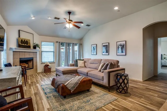 a living room with furniture a fireplace and a flat screen tv