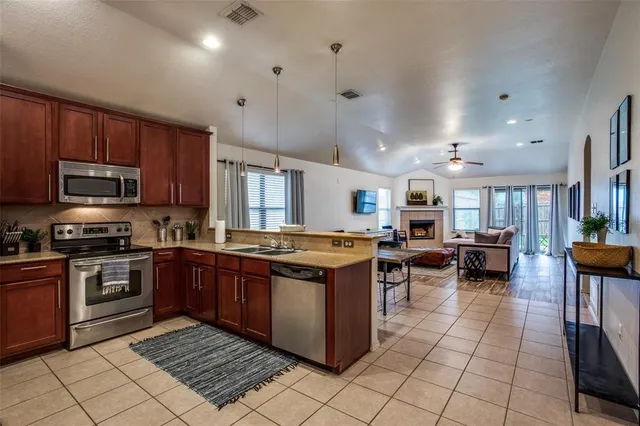 a large kitchen with stainless steel appliances granite countertop a stove and cabinets